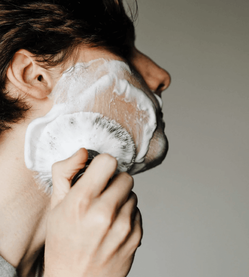 a man using the supply shaving brush