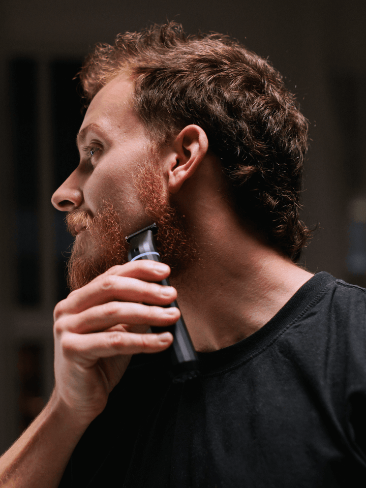 A man shaving with the supply trimmer. 