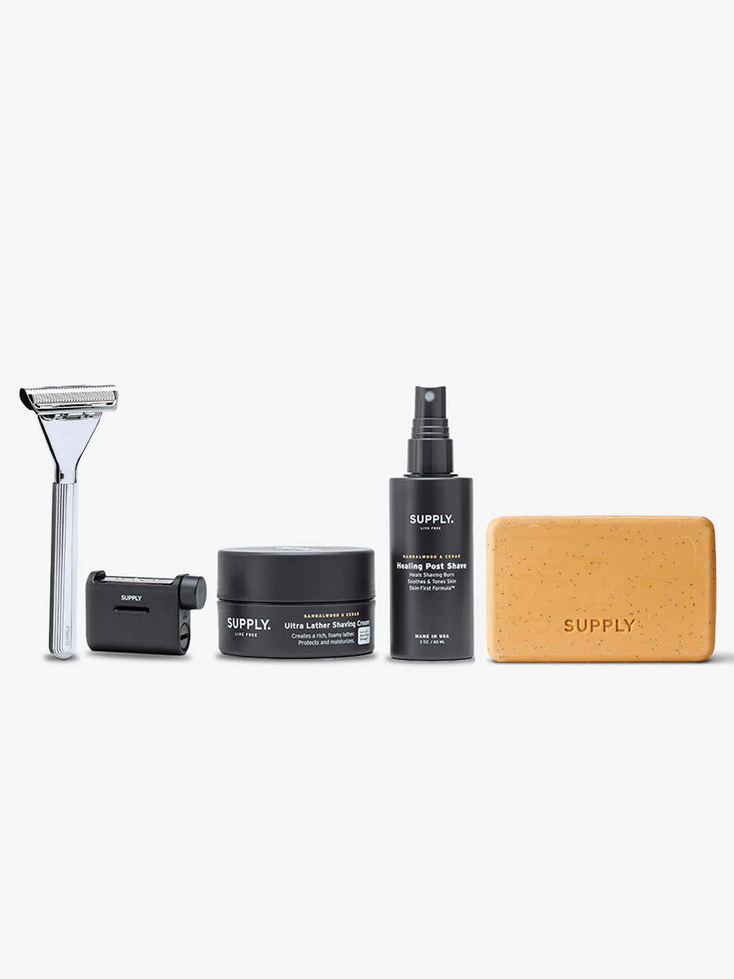 Shaving set with razor, shaving cream, aftershave, and brush on a white background.