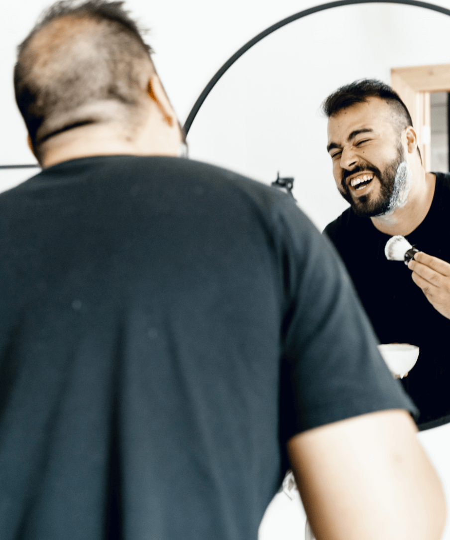 Man using supply products in front of a mirror