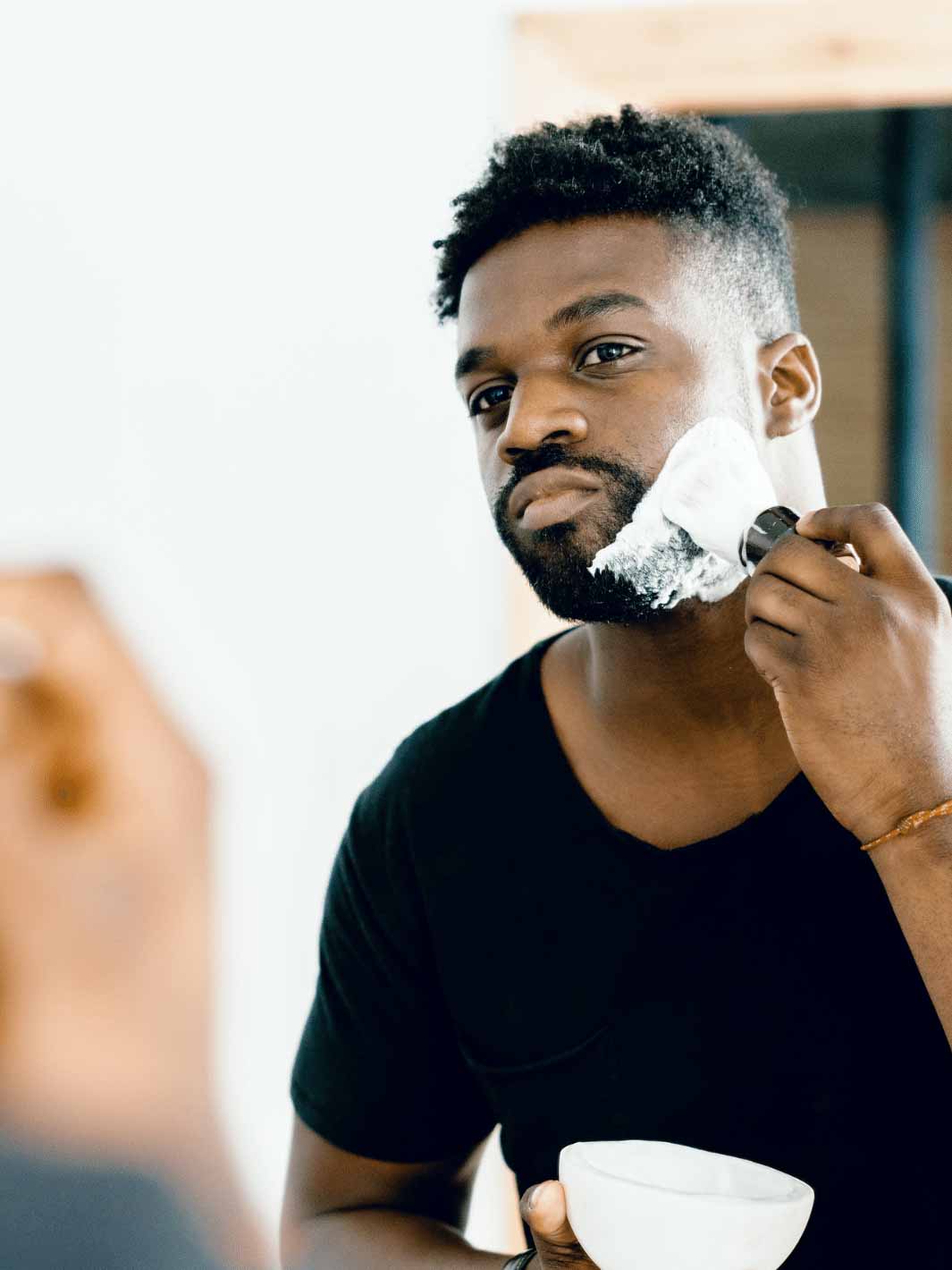 Man using the Supply shaving brush on the mirror