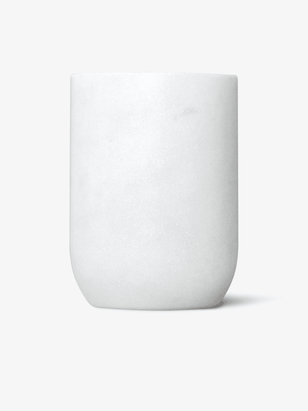 Minimalist white ceramic cup against a plain background.